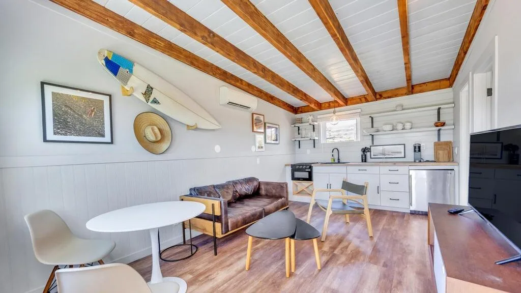 A bright living area with a small dining table beside a compact kitchen.