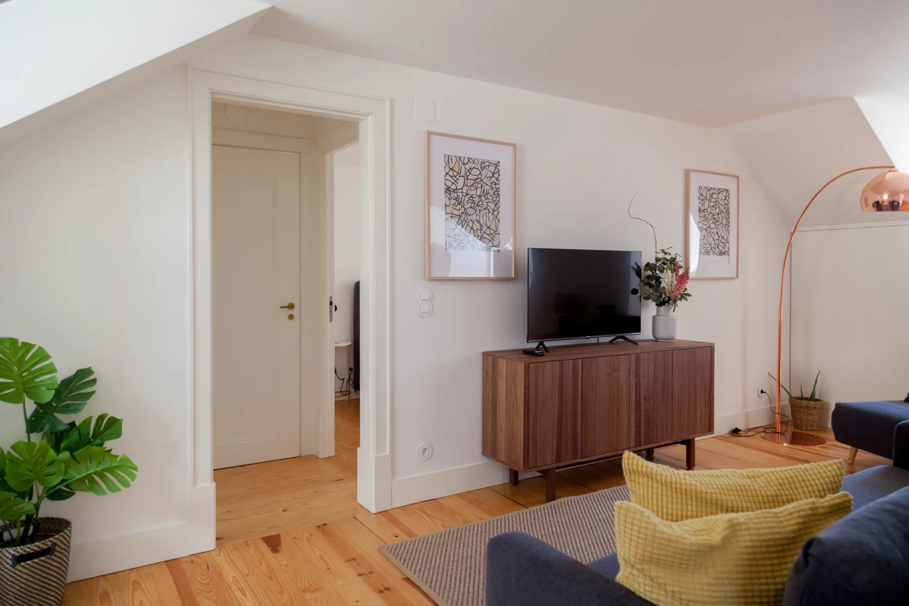 Living room with a television on a wooden cabinet and seating.