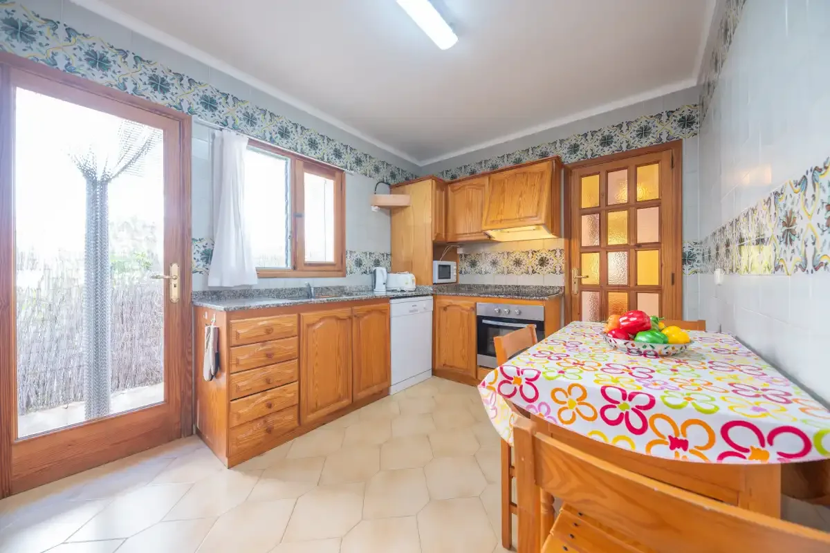A kitchen with wooden cabinets, a tiled counter, and a dining table.