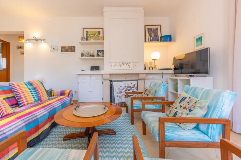 Una sala luminosa con asientos coloridos alrededor de una mesa de centro.