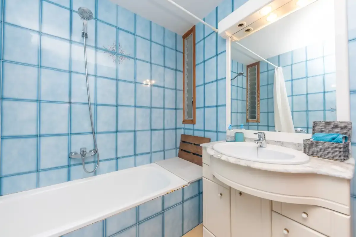 Bathroom with a bathtub beside a sink and large mirror.