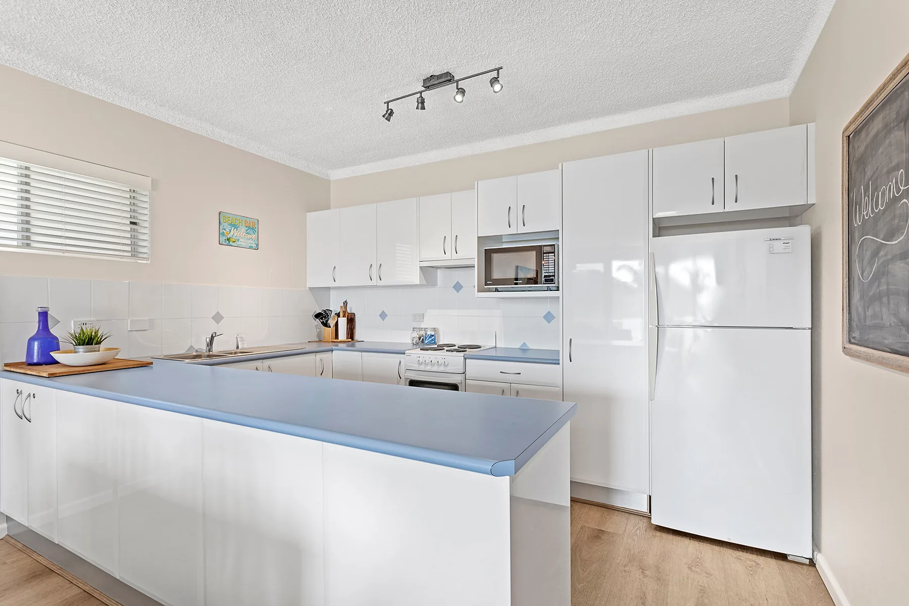 A bright kitchen with white cabinets and a broad island.