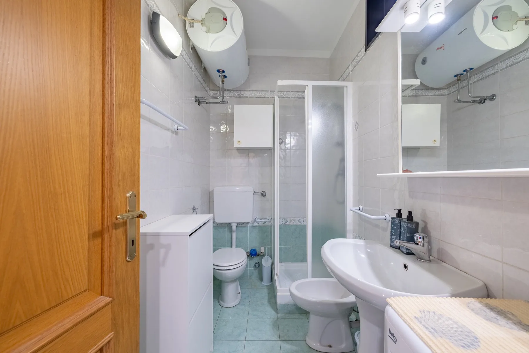 Un baño con ducha, inodoro y lavabo.