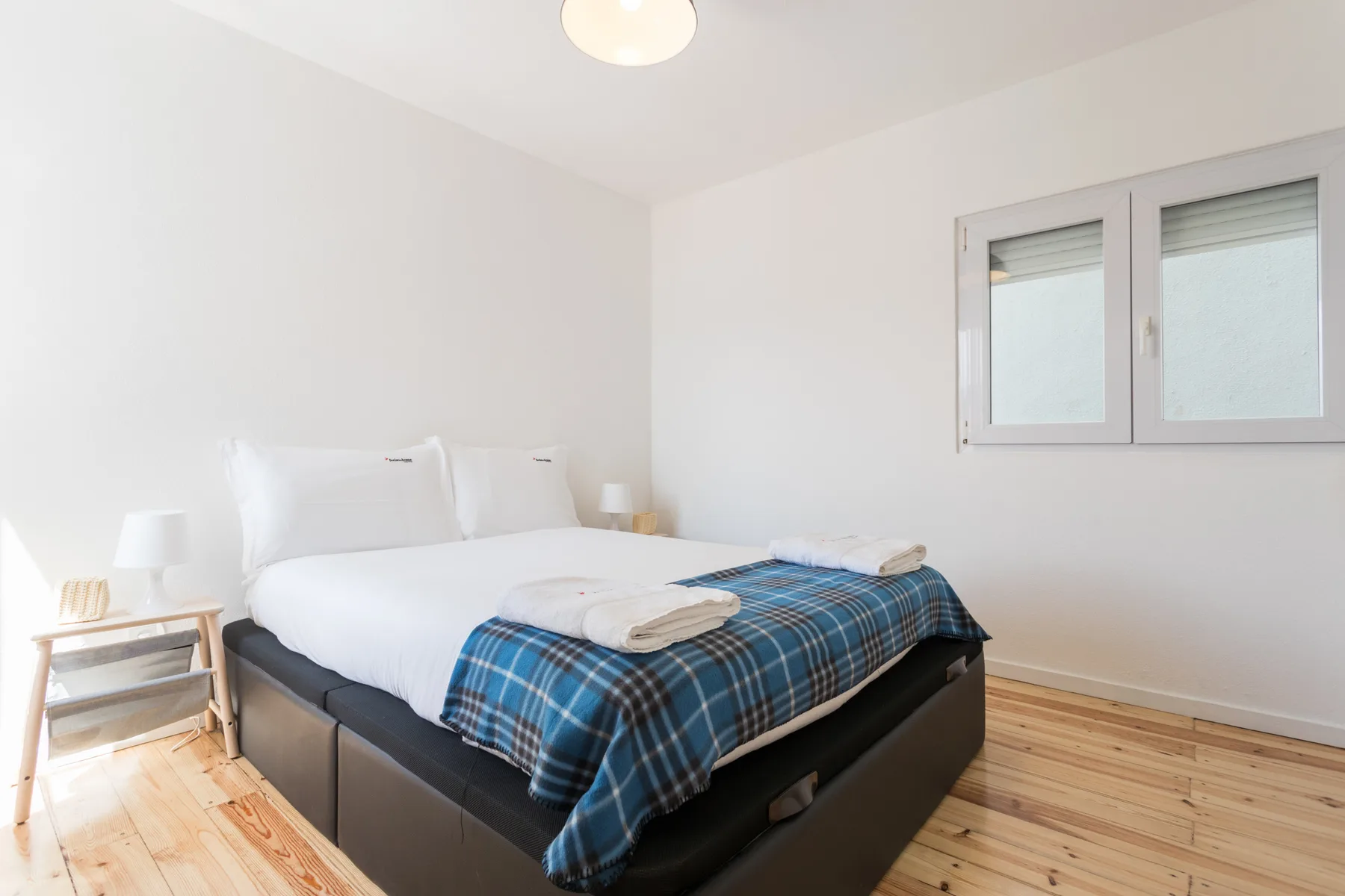 Un dormitorio luminoso con una cama y una ventana.