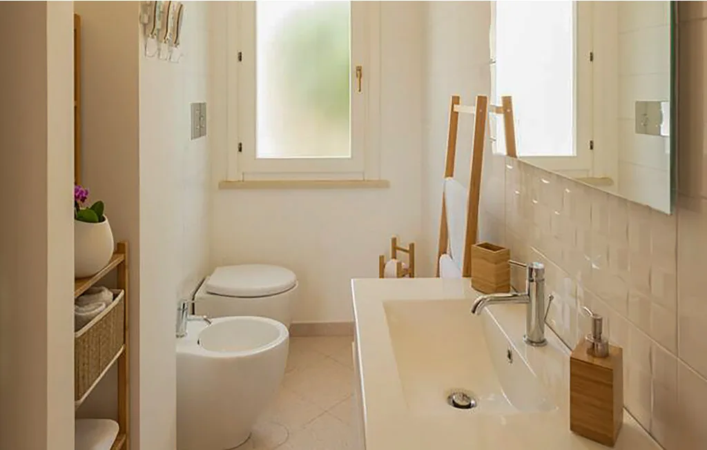 A bright bathroom with a bathtub, sink, and frosted window.