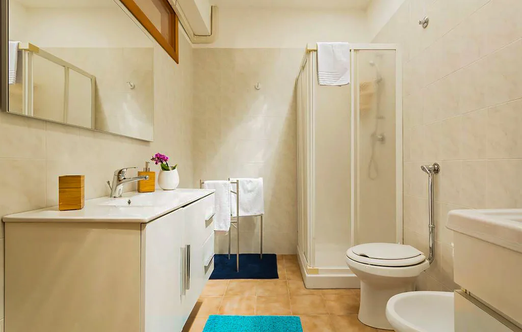 A bathroom with a sink, shower, and toilet.