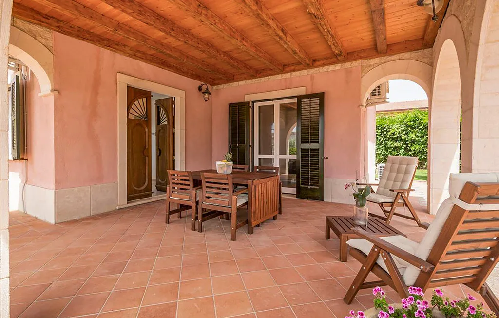 A covered patio with a wooden dining table and seating.