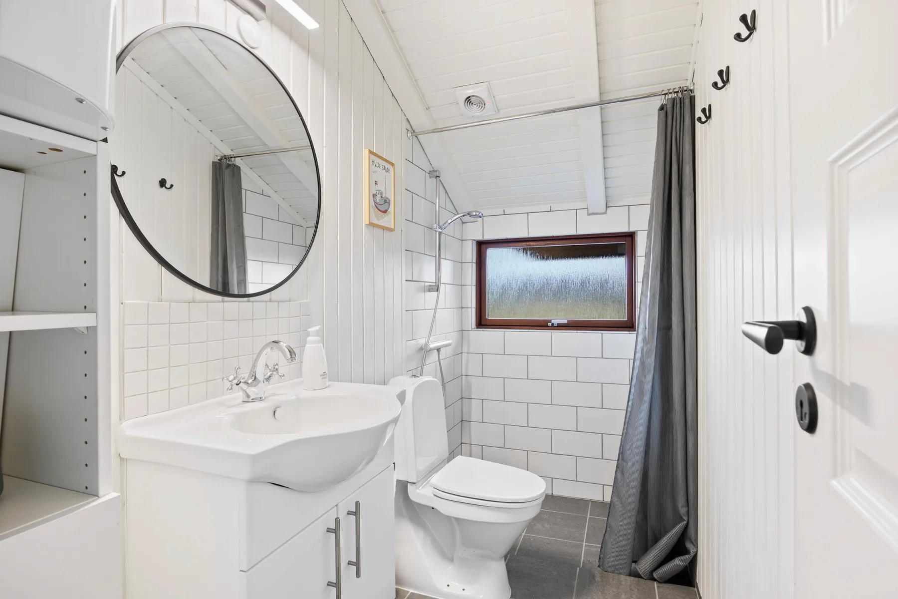 Un baño luminoso con lavabo, inodoro y ducha.