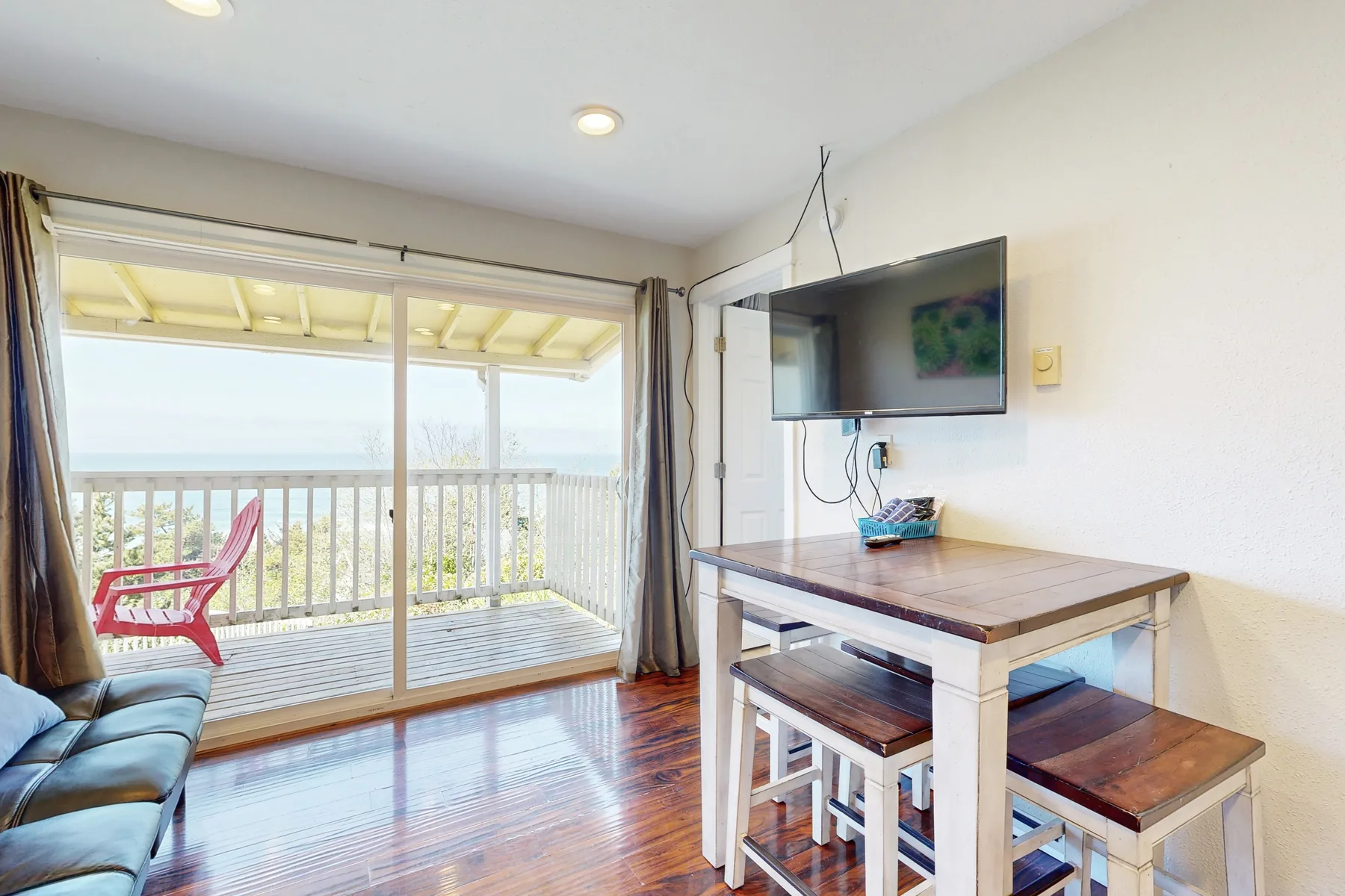 A dining area with a wooden table and seating beside sliding glass doors.