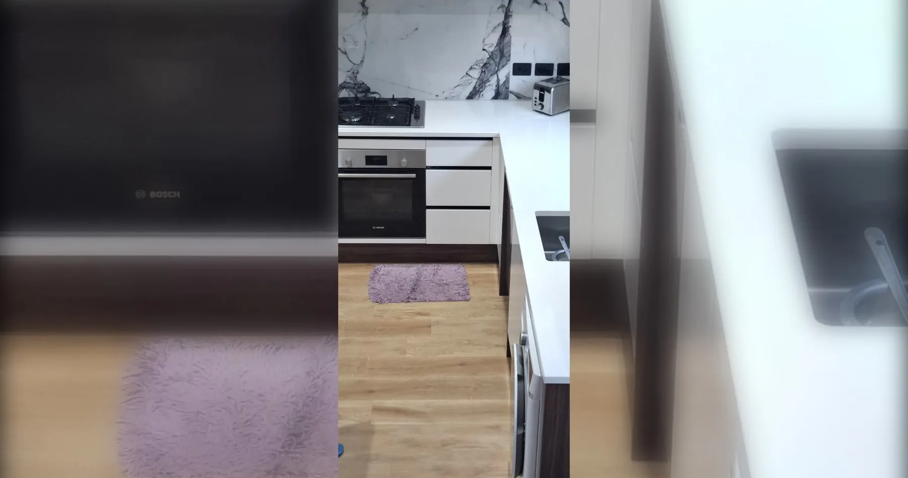 A modern kitchen with white cabinets and a wood floor.