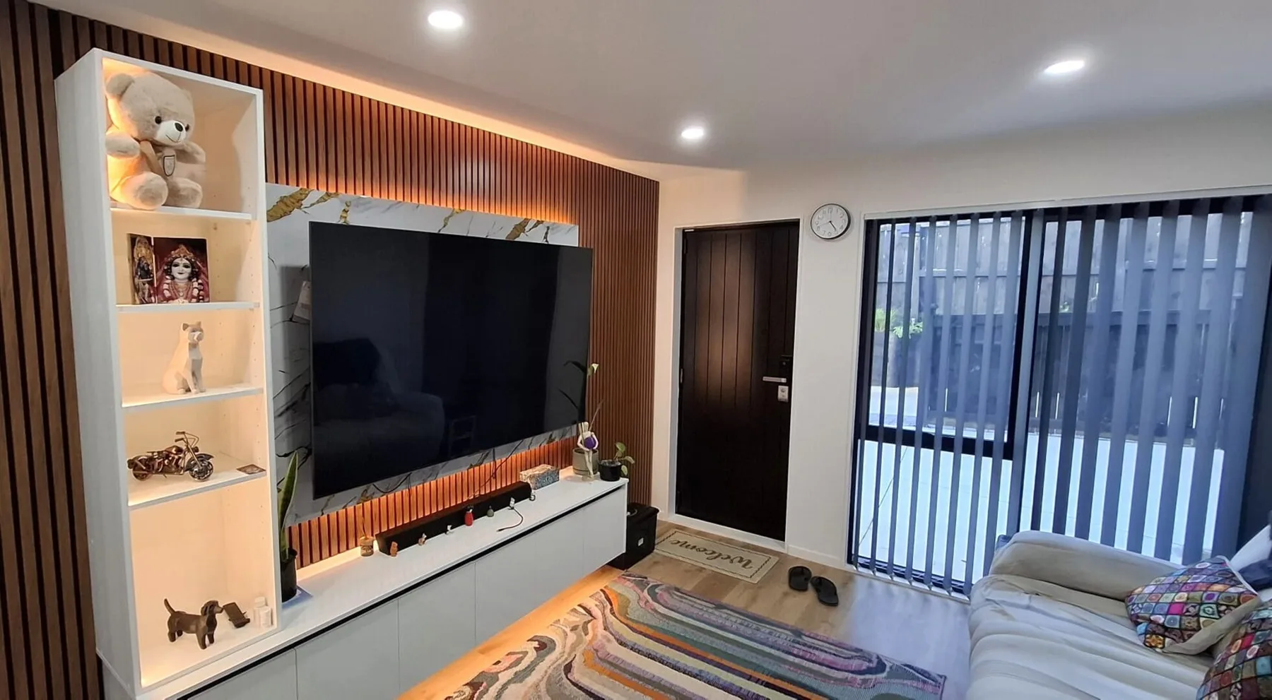 A living room with a television, seating, and sliding glass doors.