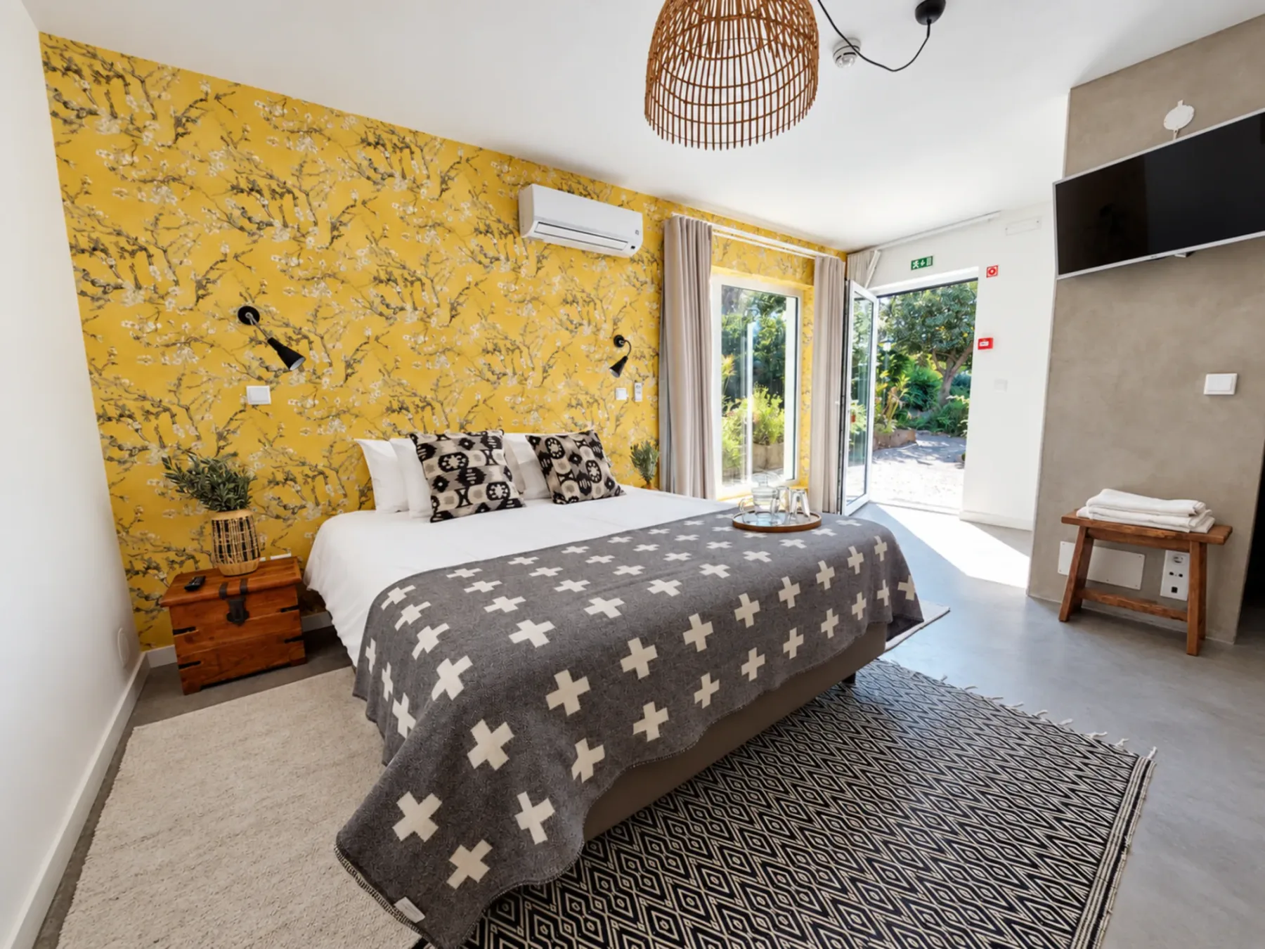 Vila Louro bedroom with floral yellow wall and gray bed