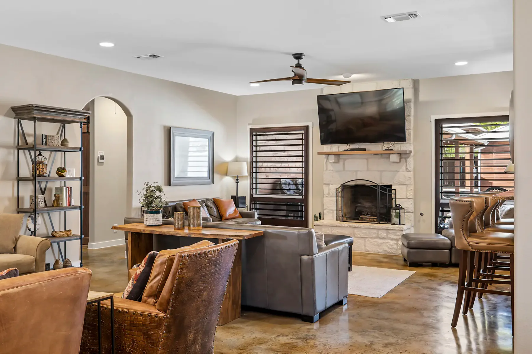 A living room with seating arranged around a fireplace and wall-mounted television.