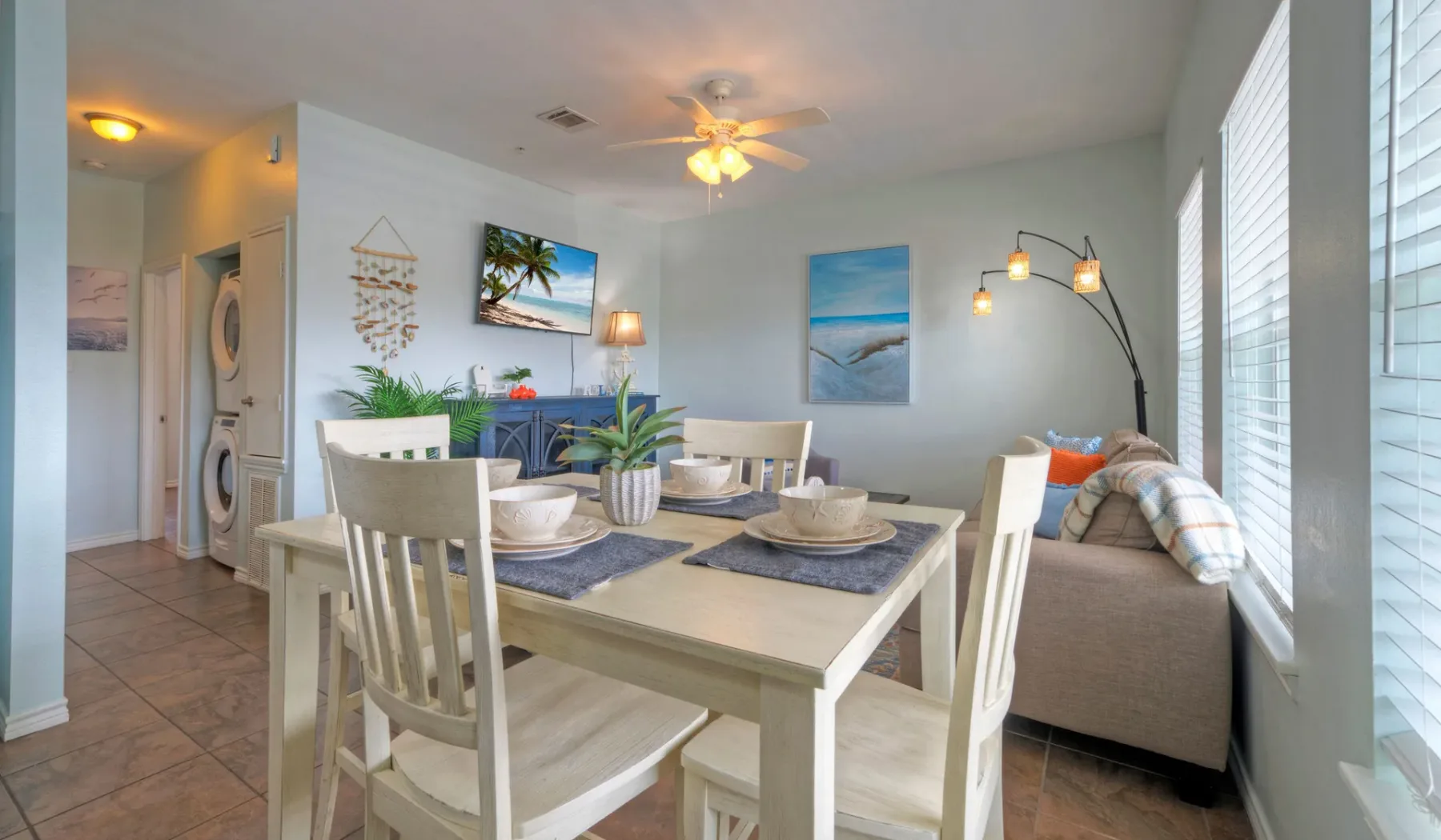 A dining area with a table and chairs beside a living room seating area.