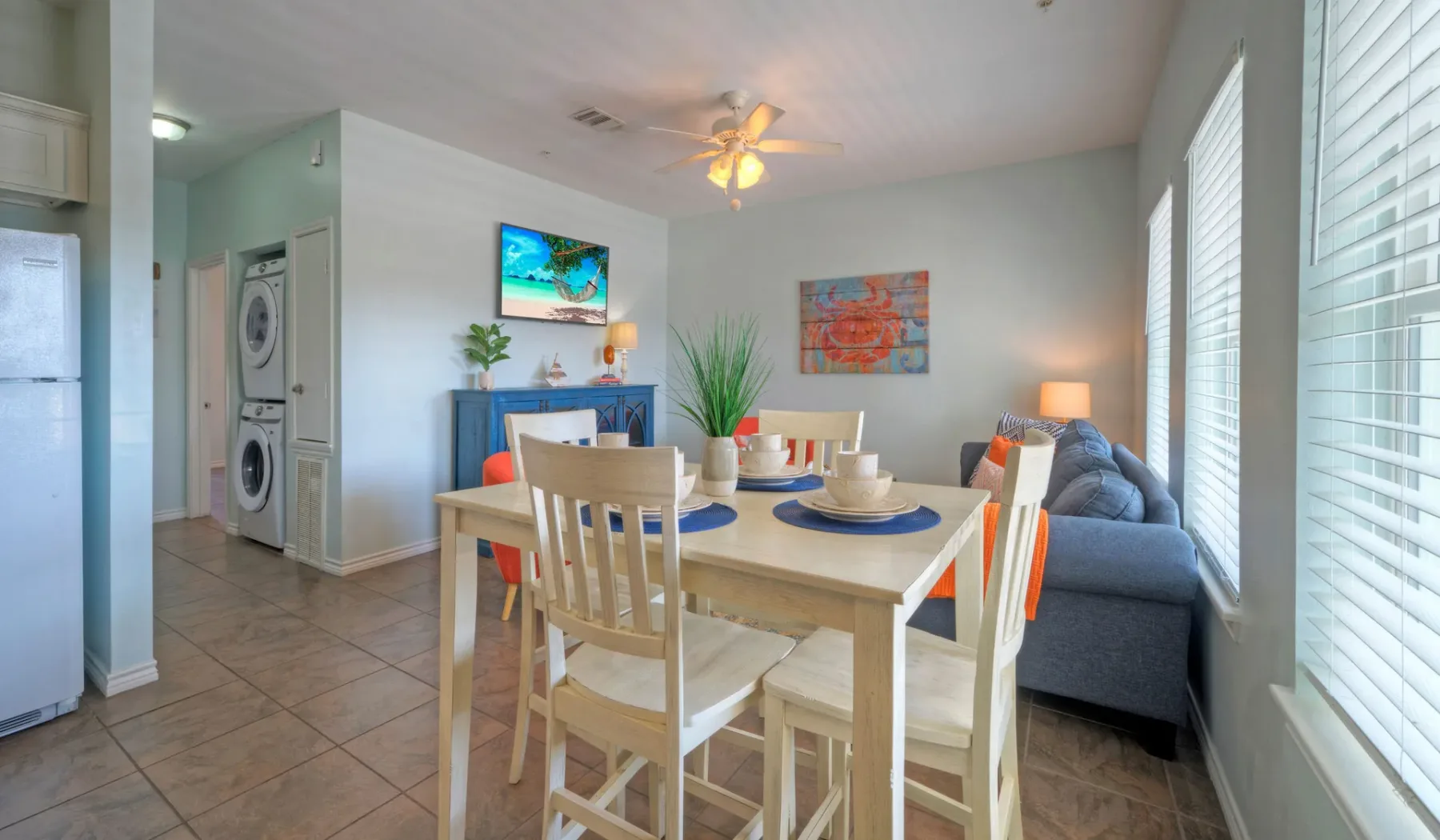 Dining area with a table and chairs beside a living room seating area.