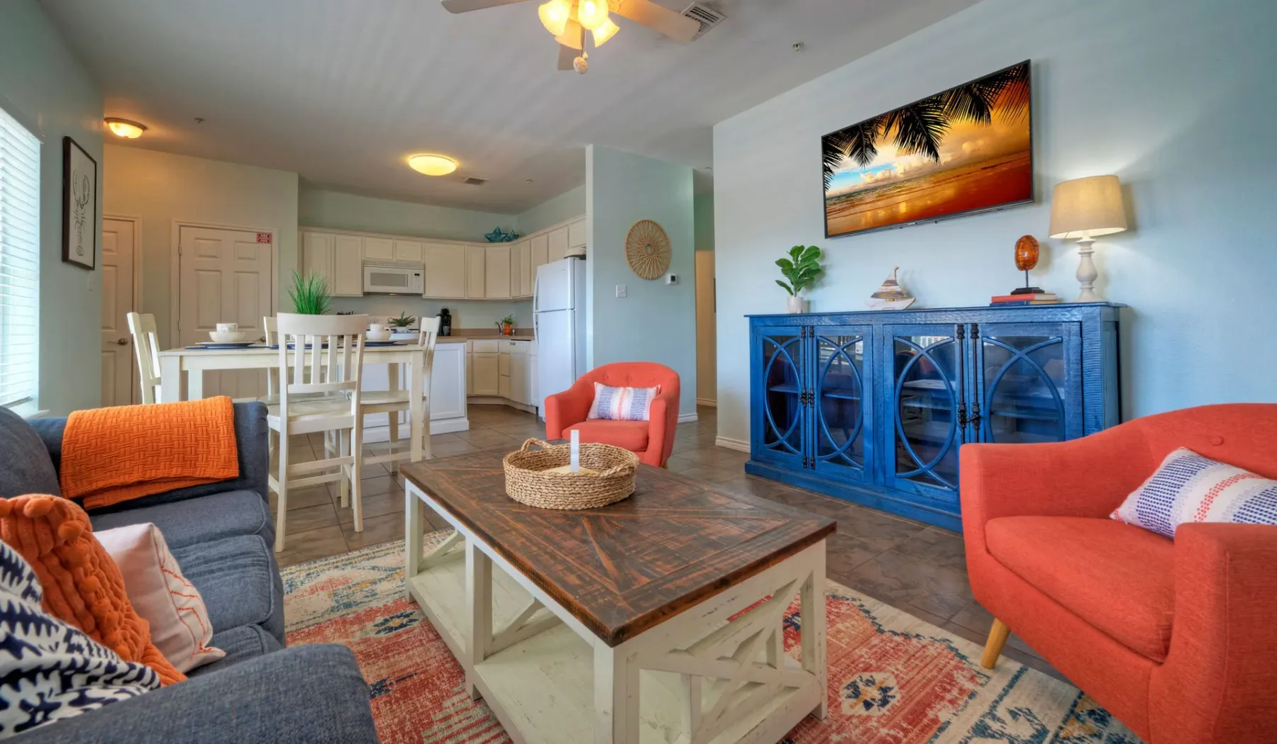 A living room with colorful seating and a wooden coffee table.