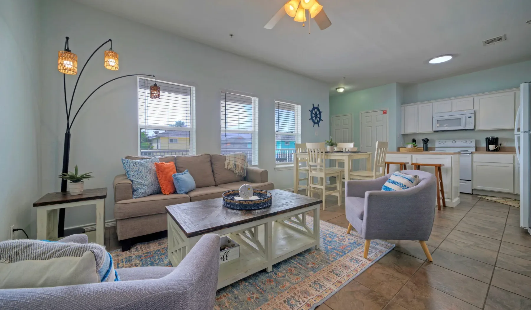 A living area with seating and a dining table beside an open kitchen.