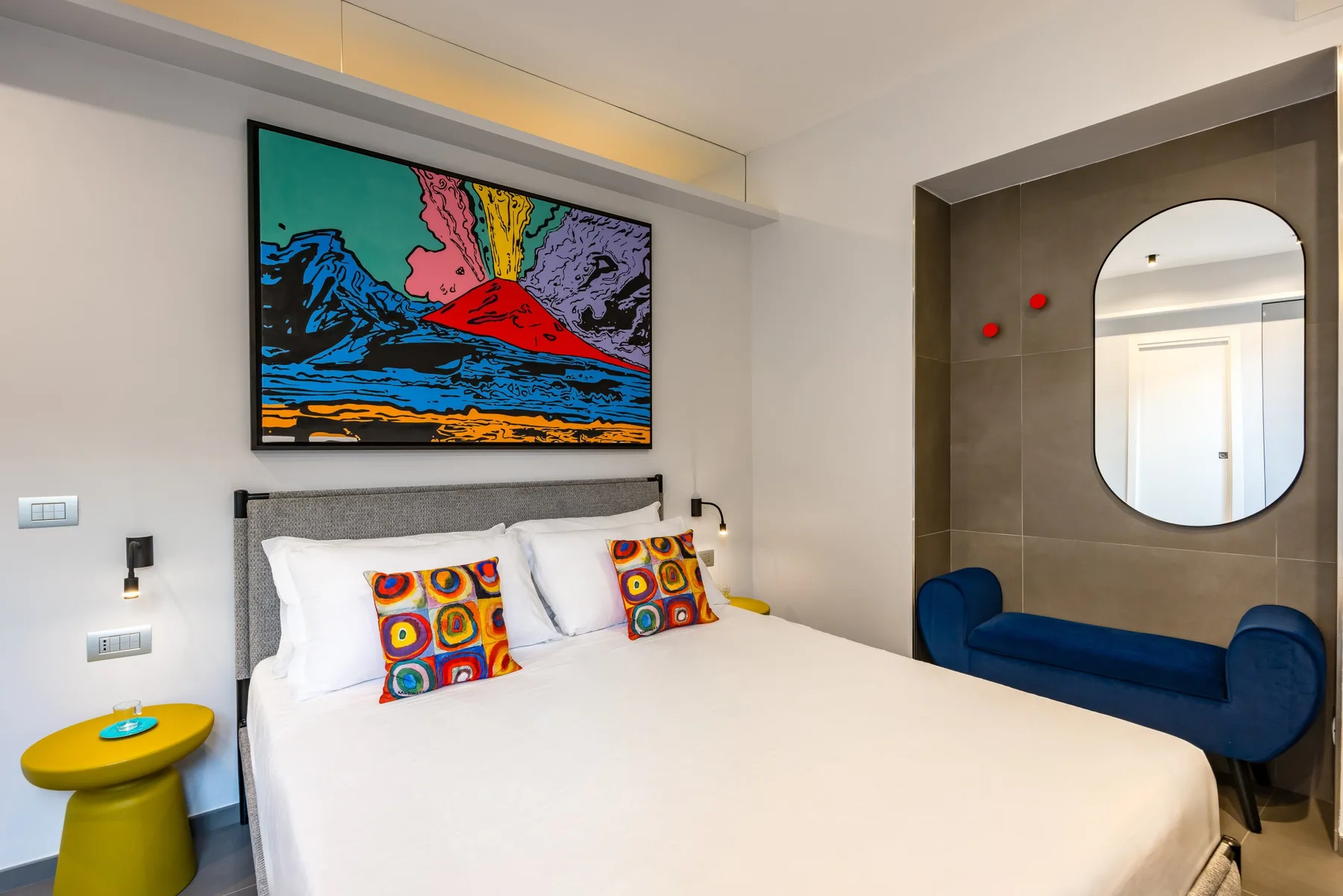 Un dormitorio con una cama grande y una obra colorida enmarcada encima.