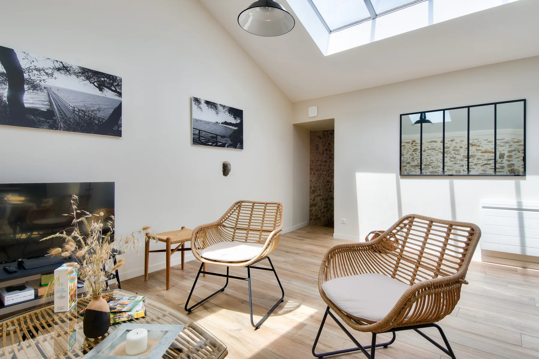 A bright living room with wicker seating and a skylight.
