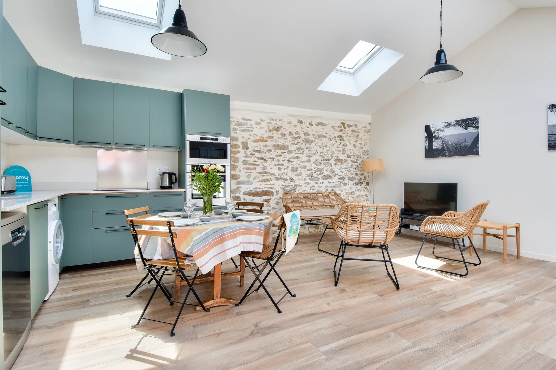 A bright open-plan living and dining area with a kitchen and seating.