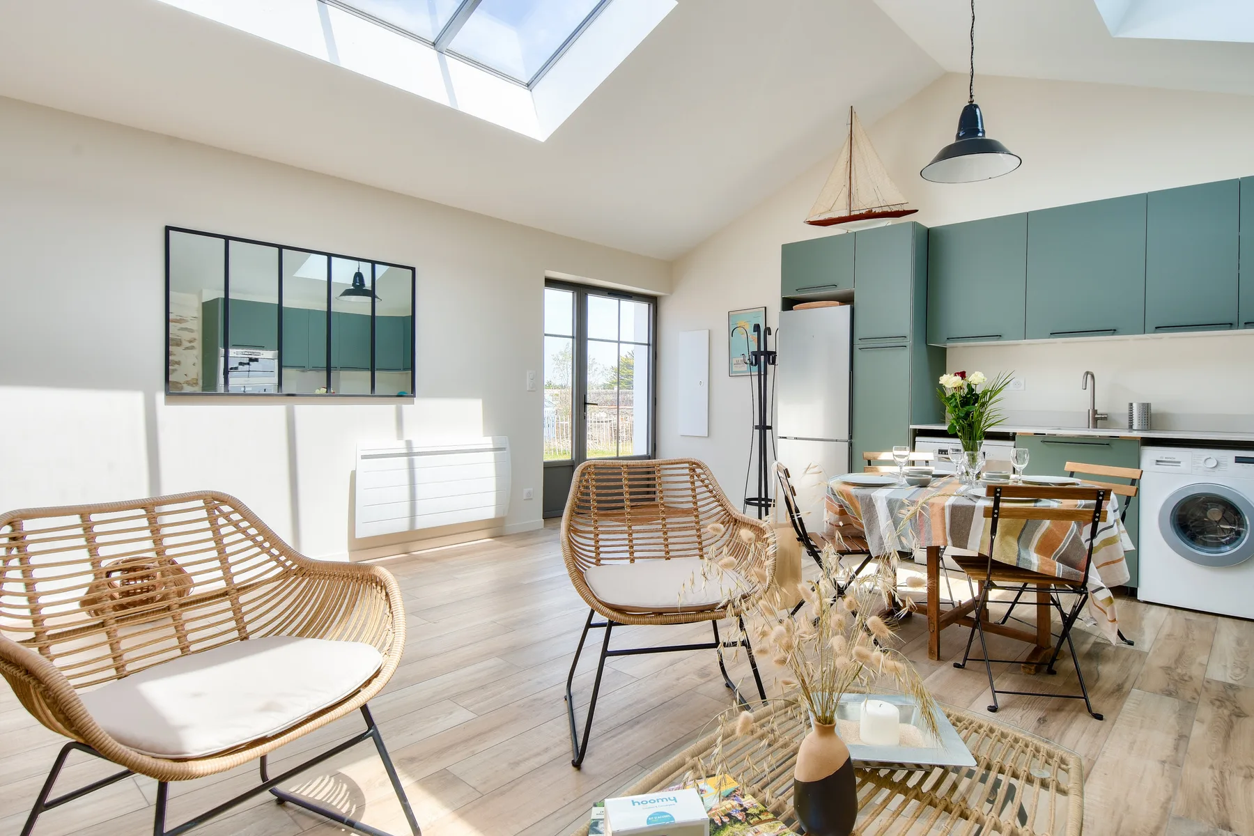 A bright open-plan kitchen and dining area with a skylight and seating.