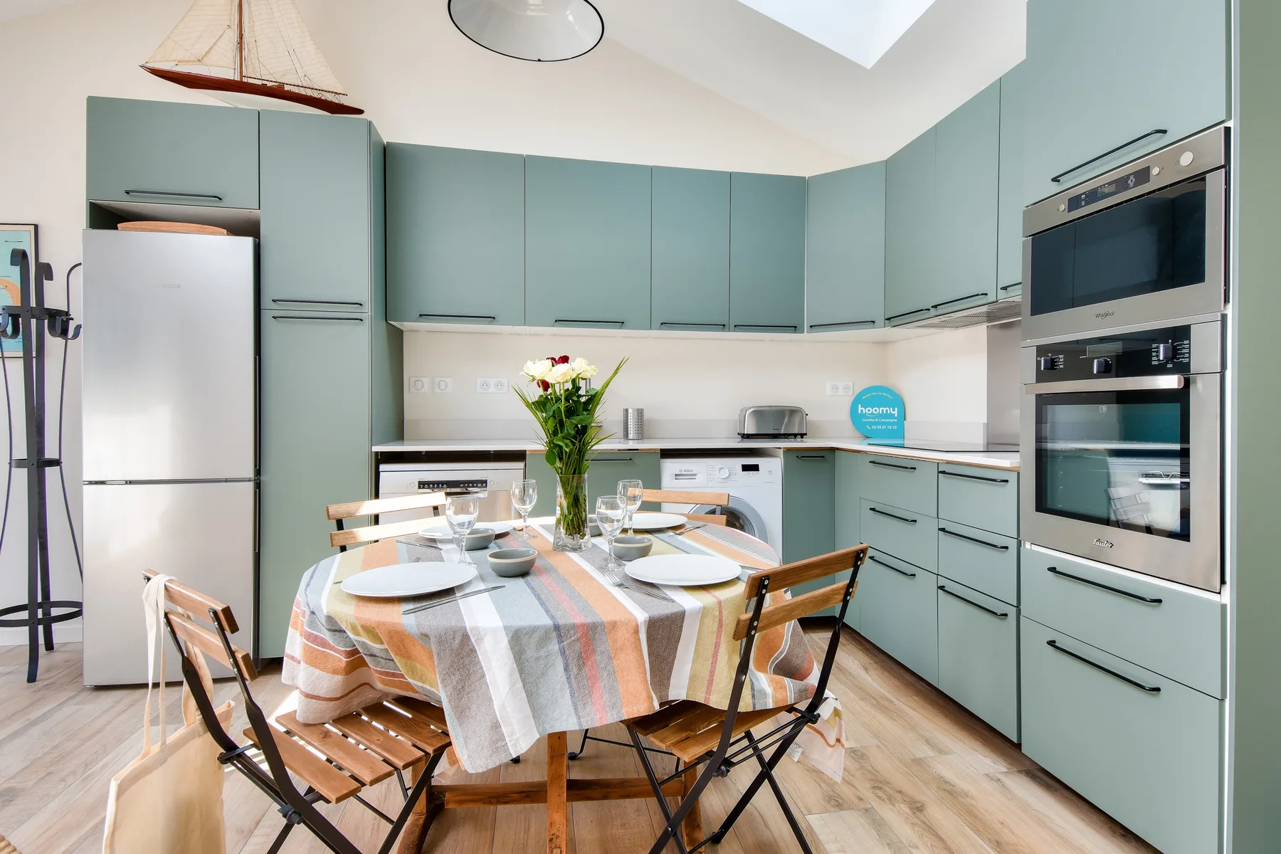 A kitchen with pale blue cabinets and a dining table.