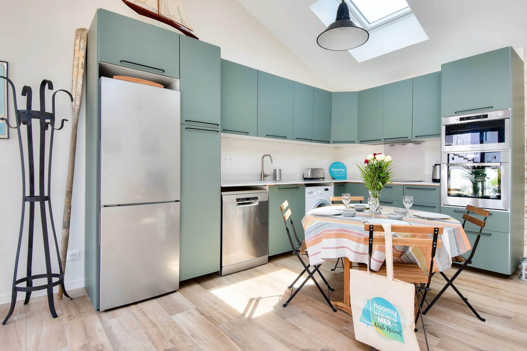 A bright kitchen with teal cabinets and a dining table.
