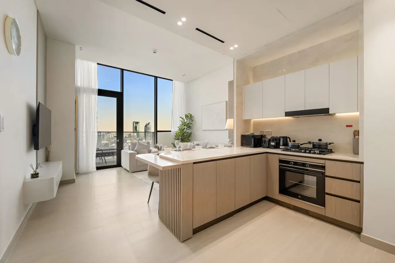 Una cocina-comedor diáfana y luminosa, con grandes ventanas y una isla central.