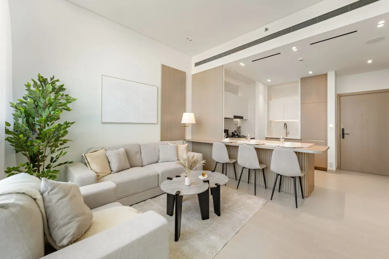 Una luminosa sala-comedor de planta abierta con asientos y una barra de cocina.