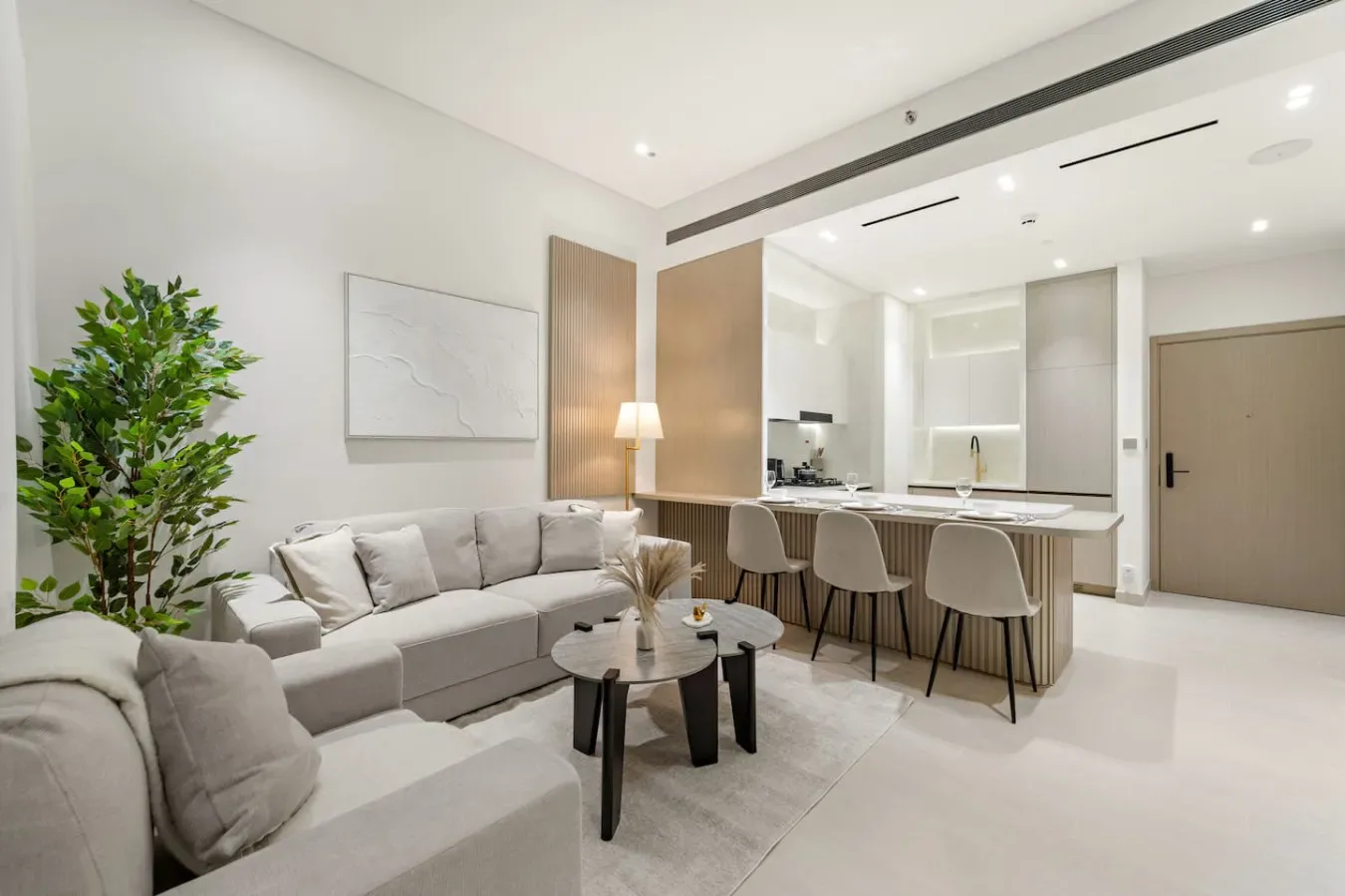 Una luminosa sala de estar y cocina de concepto abierto, con zona de estar y barra de desayuno.