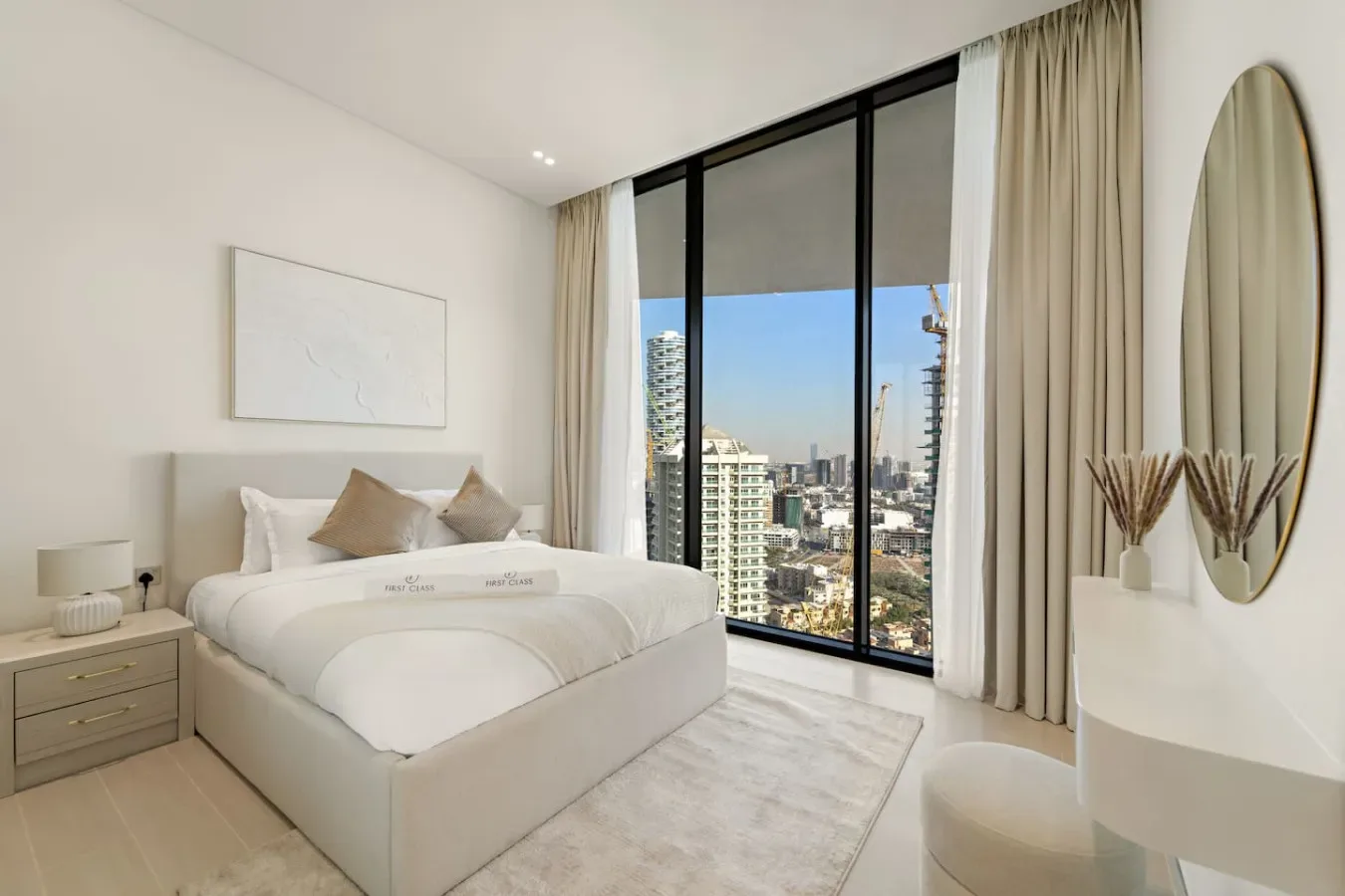 Un dormitorio luminoso con una cama junto a una gran ventana con vistas a la ciudad.