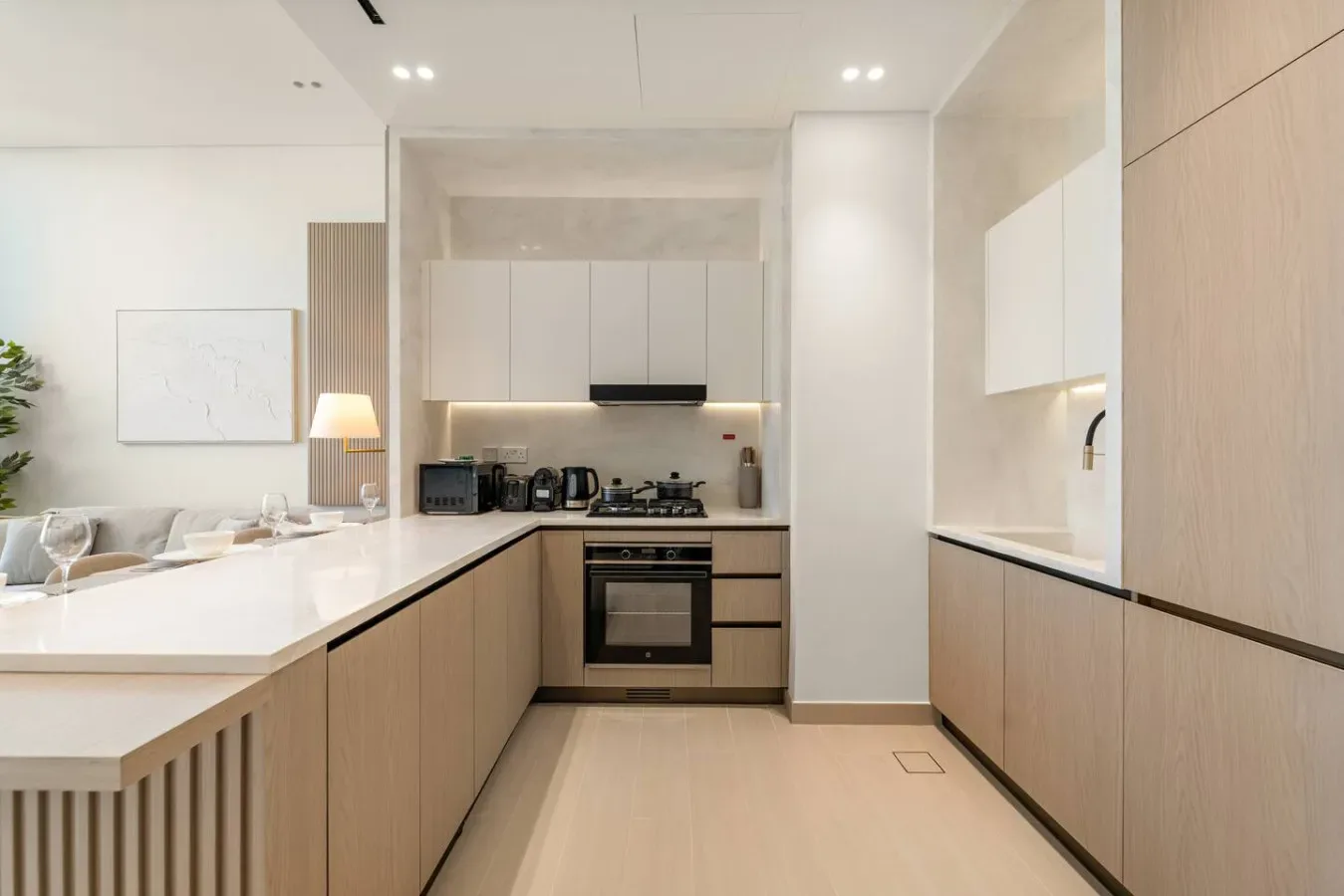 Una cocina moderna y luminosa con gabinetes de madera clara y una zona de cocción central.
