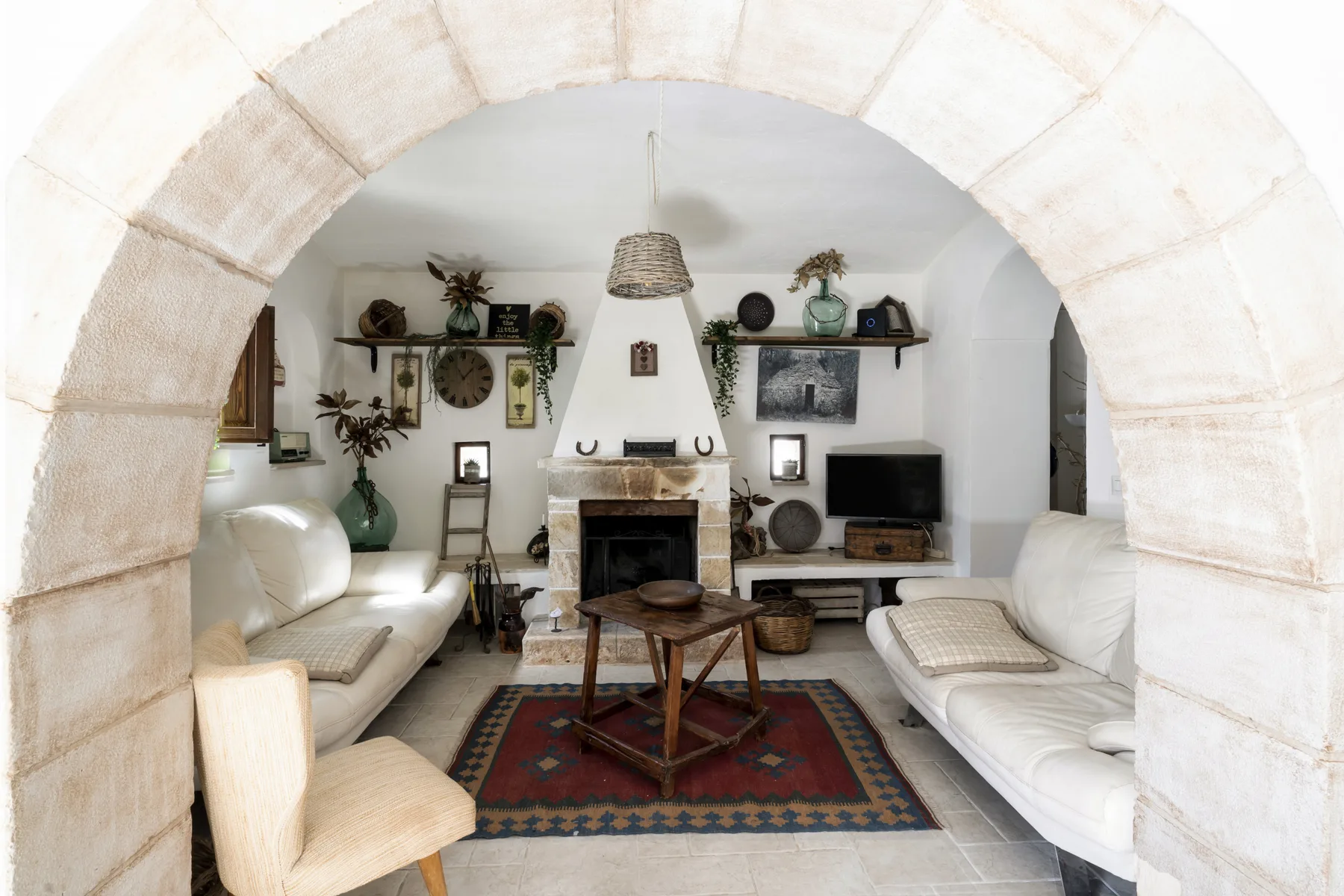 Una sala de estar con asientos dispuestos alrededor de una chimenea y una mesa de centro.