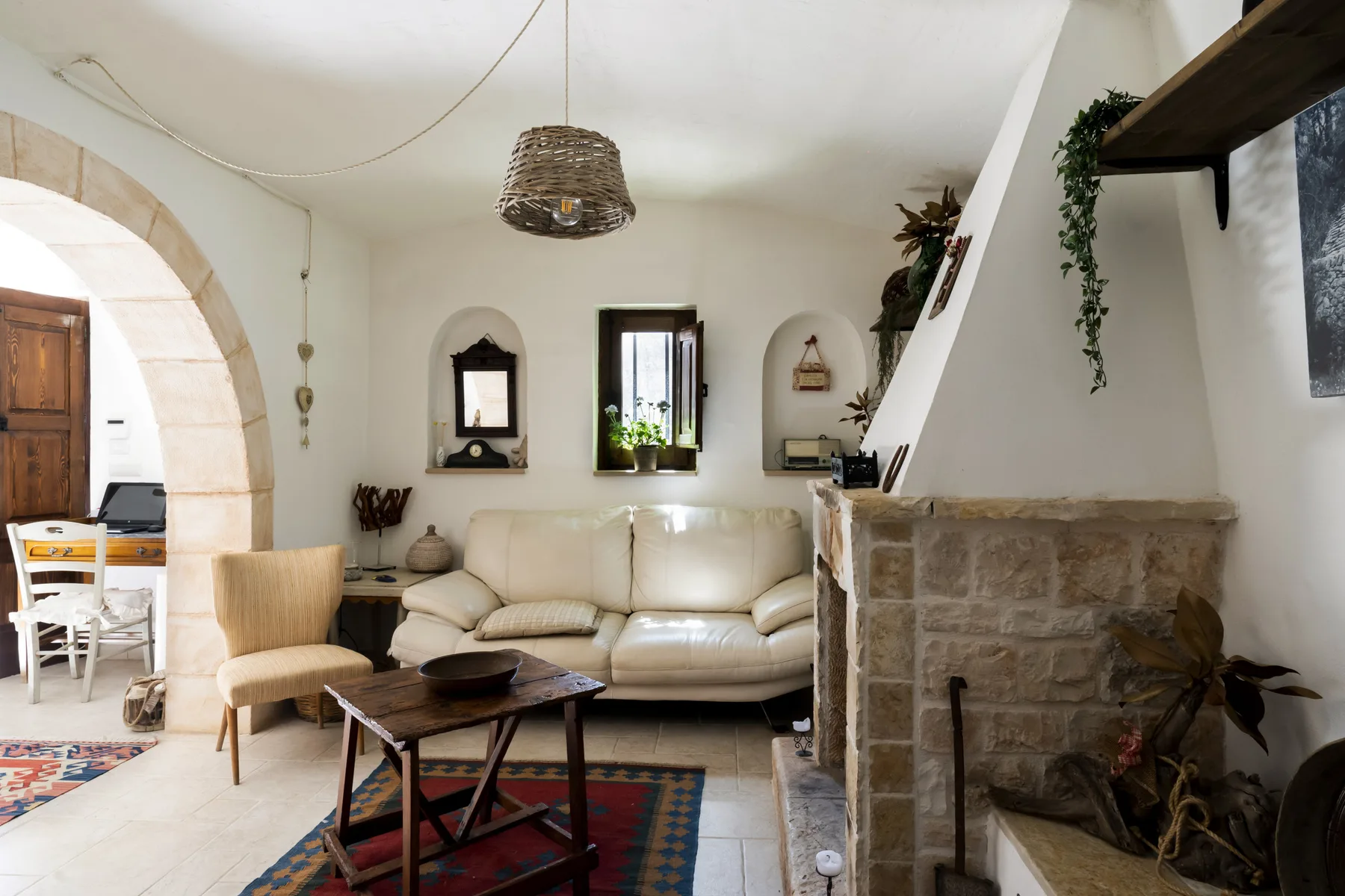 Una sala de estar con asientos color crema, una mesa de centro y una chimenea de piedra.