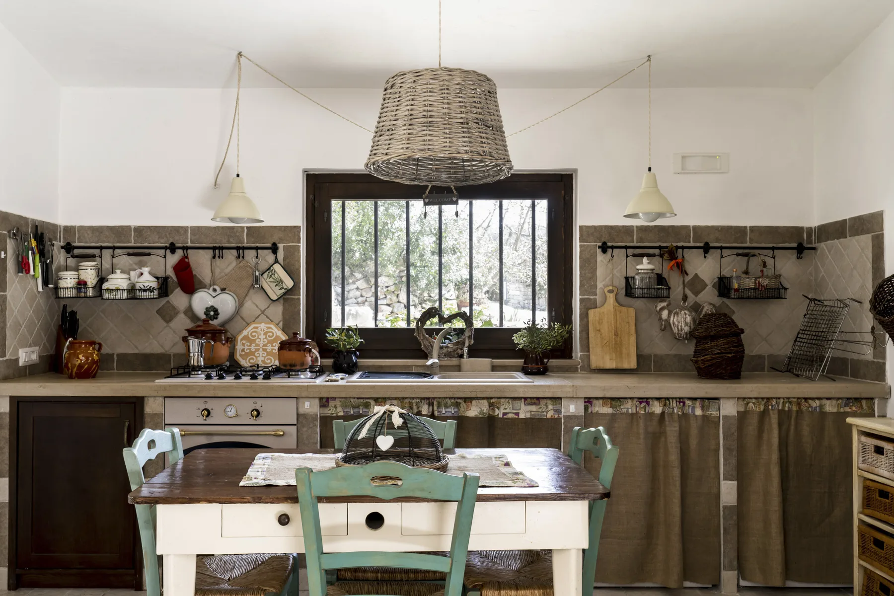 Cocina y comedor con una mesa bajo una ventana grande.