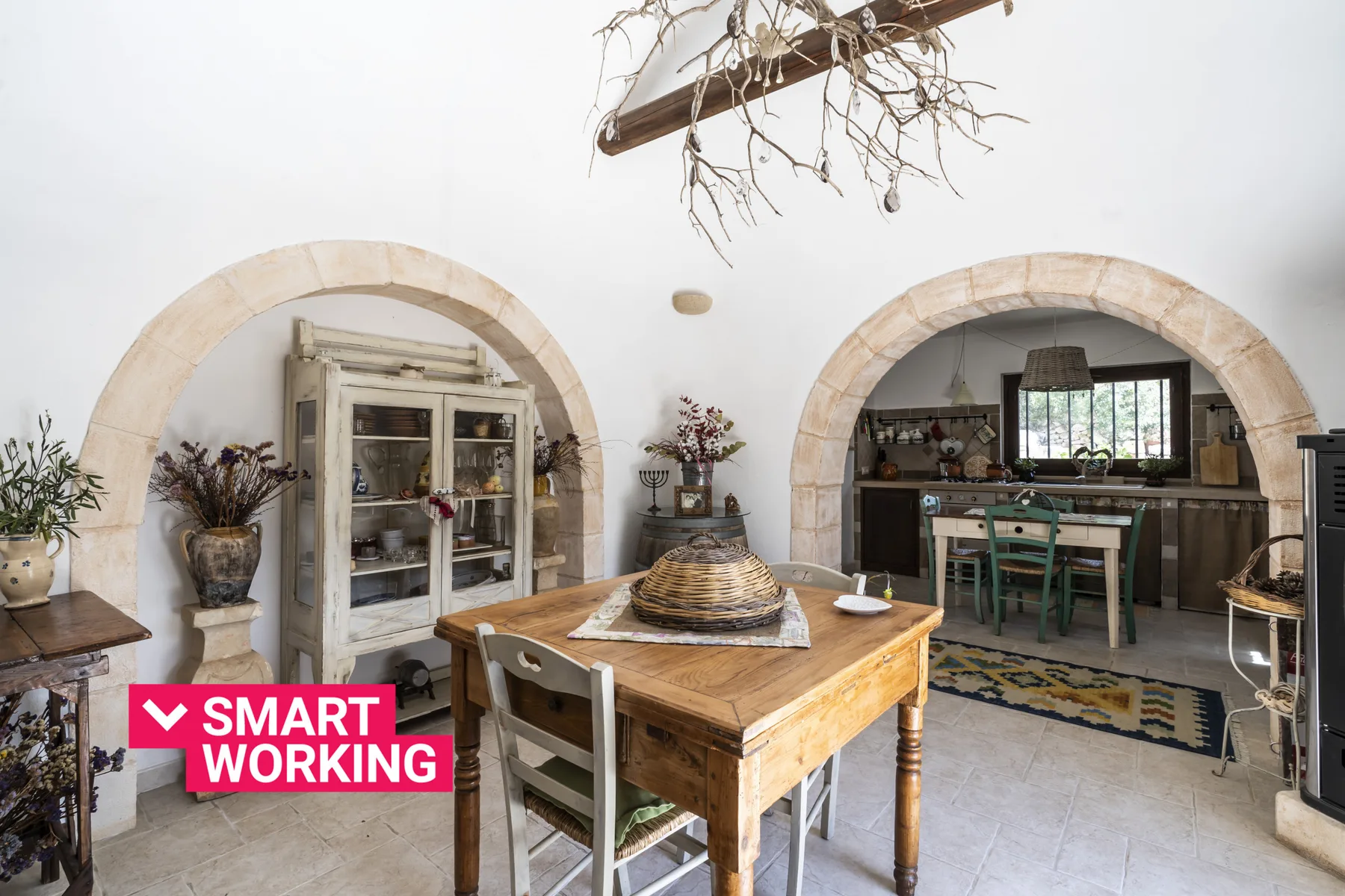 Un comedor con una mesa de madera se encuentra entre dos arcos.