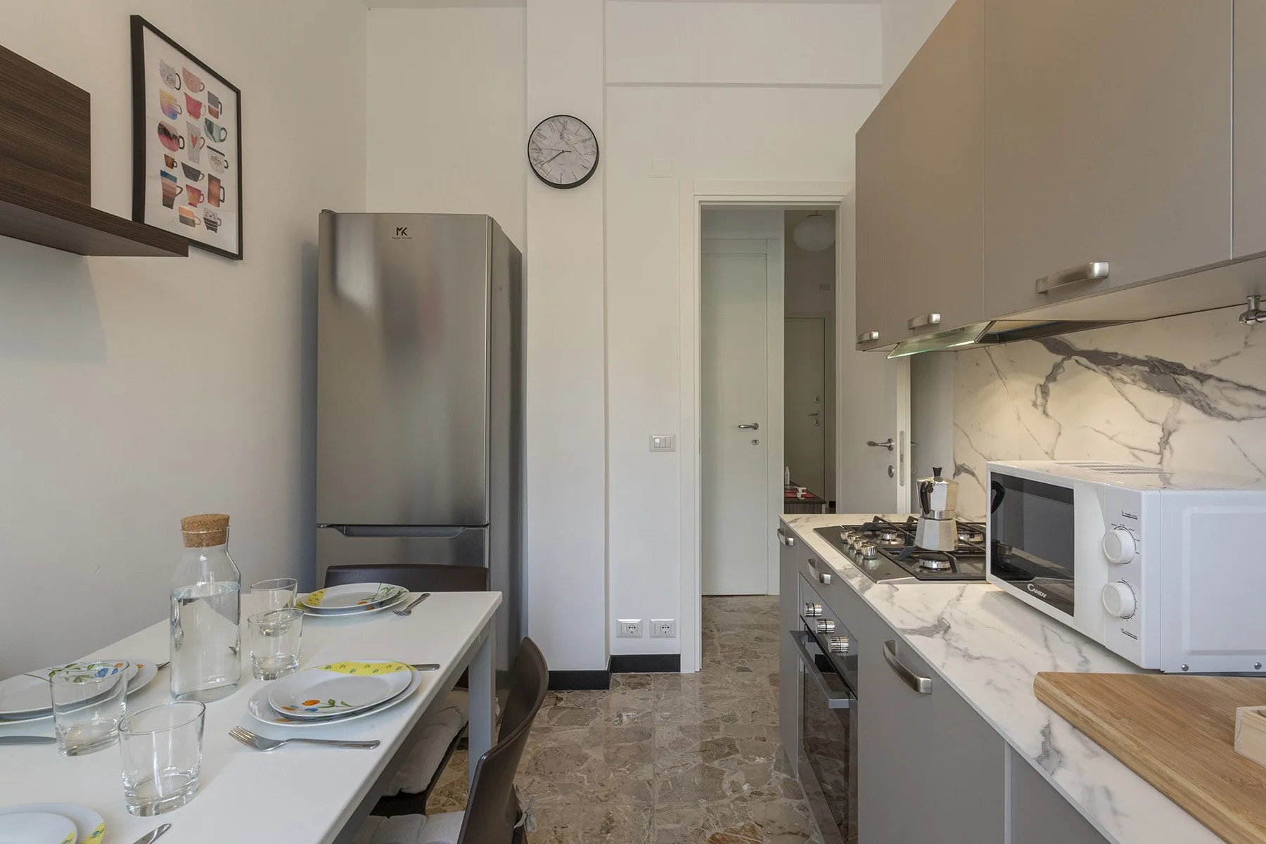 Una cocina moderna con una mesa de comedor y electrodomésticos junto a la encimera.