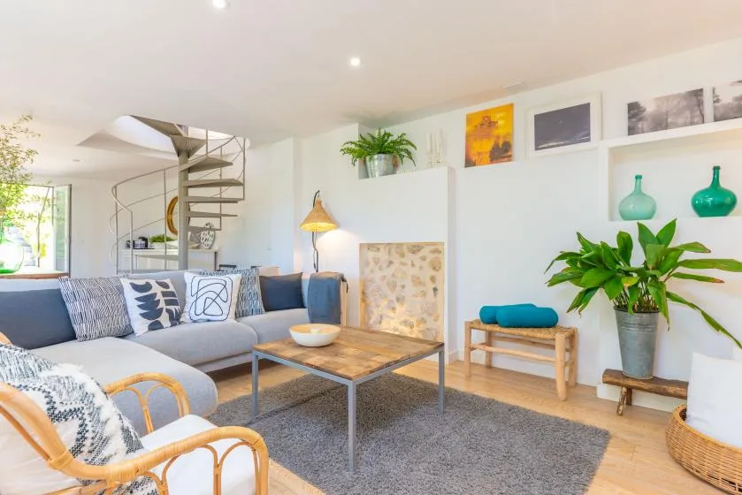 Una sala luminosa con asientos, una mesa de centro y plantas de interior.