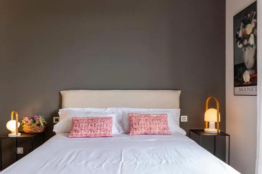A bedroom with a neatly made bed and matching bedside tables.