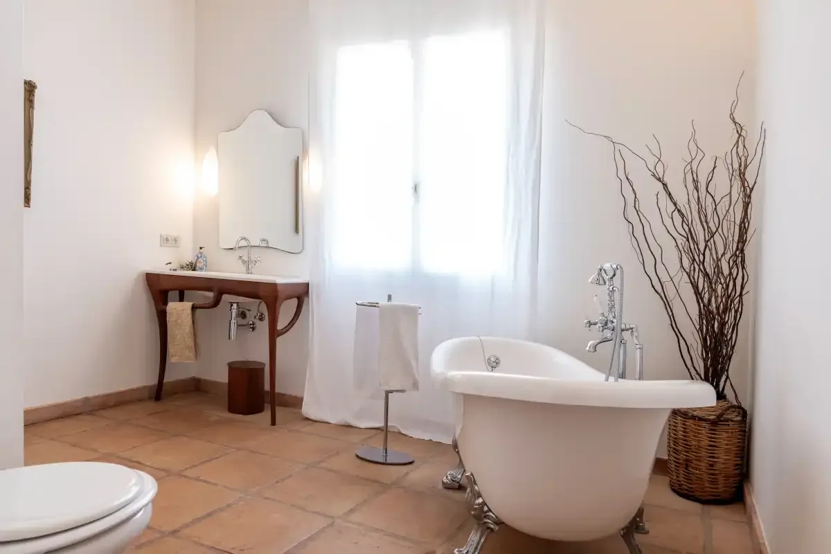 A bright bathroom with a freestanding bathtub and a wooden vanity.