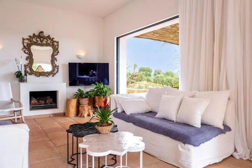 A bright living room with a white sofa beside a large window.