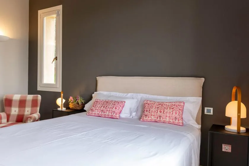 A bedroom with a neatly made bed and patterned accent pillows.