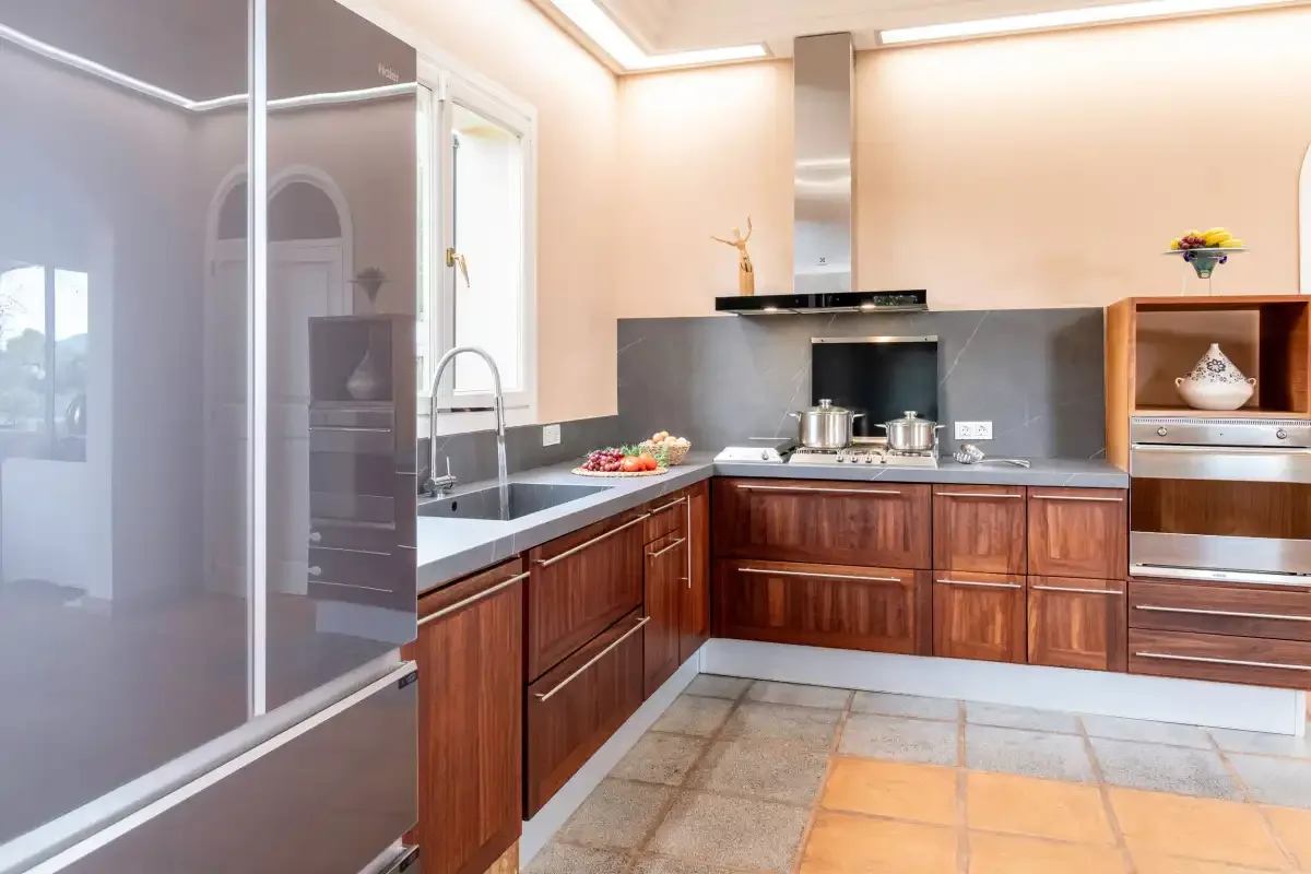A modern kitchen with wooden cabinets, a cooktop, and a sink.
