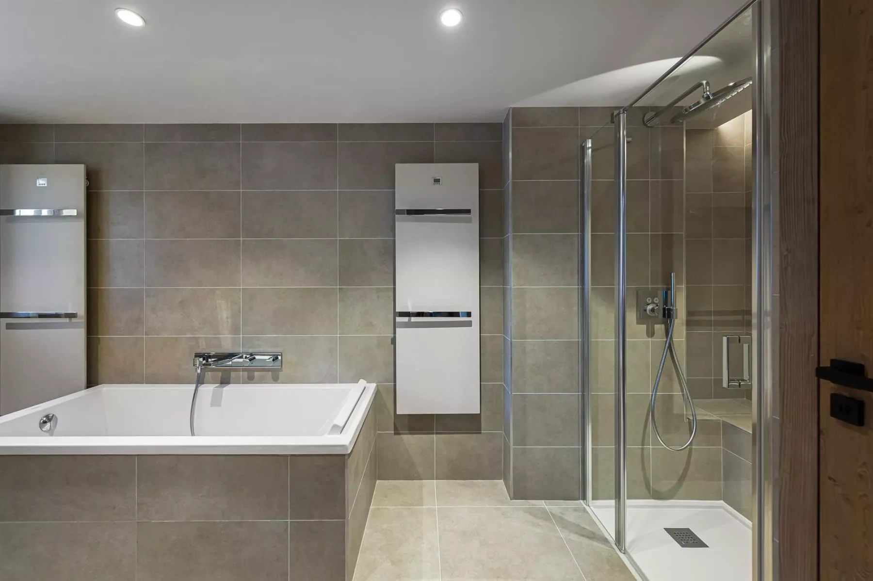 A tiled bathroom with a bathtub and glass shower.