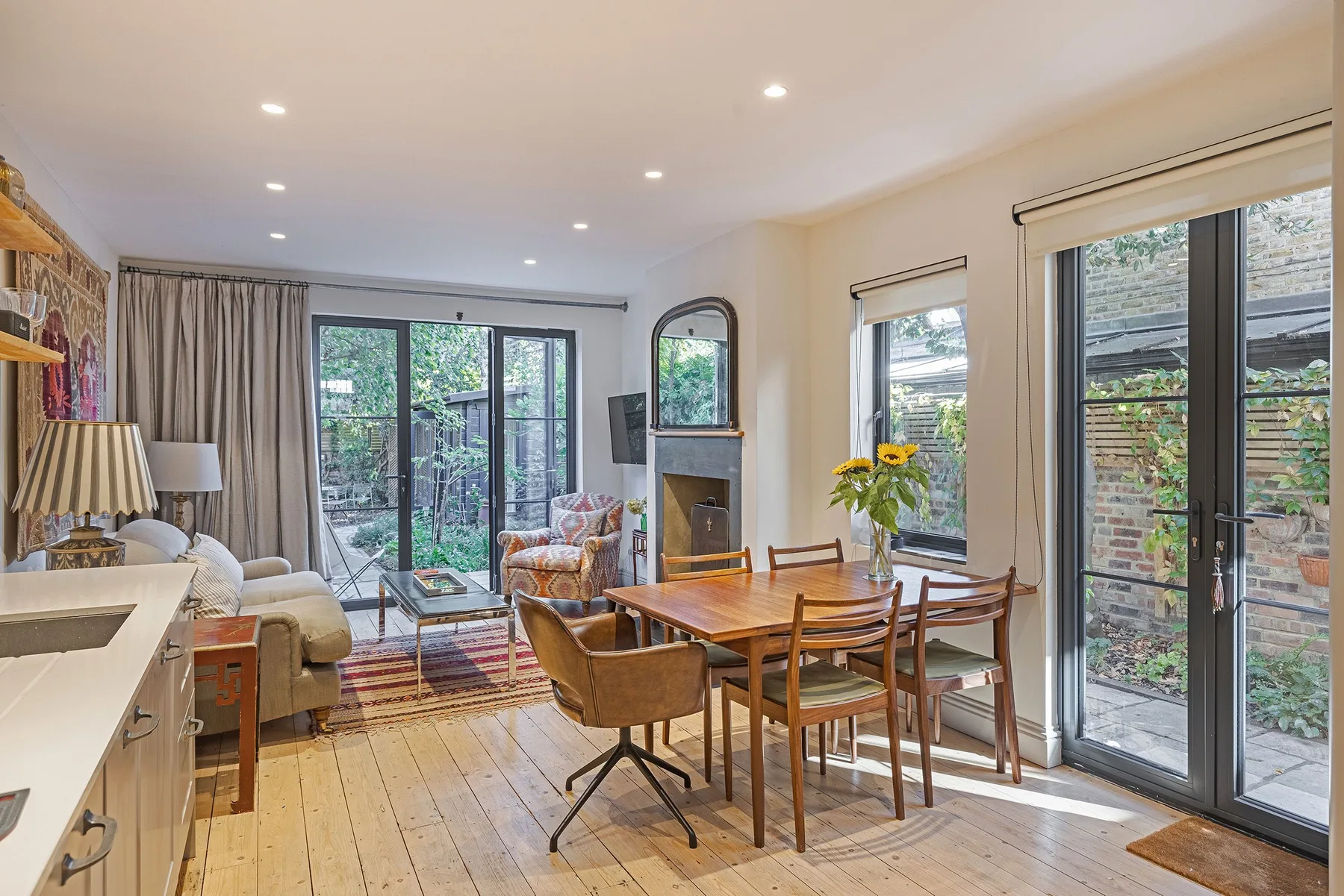 Una luminosa sala de estar y comedor de planta abierta con grandes puertas de vidrio hacia el patio.