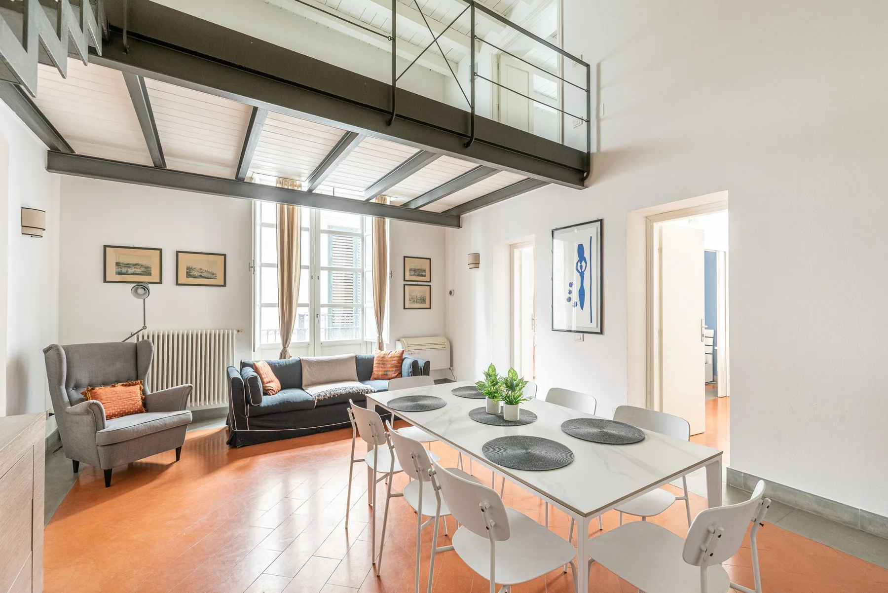 Una luminosa sala de estar y comedor diáfana con mesa y asientos.