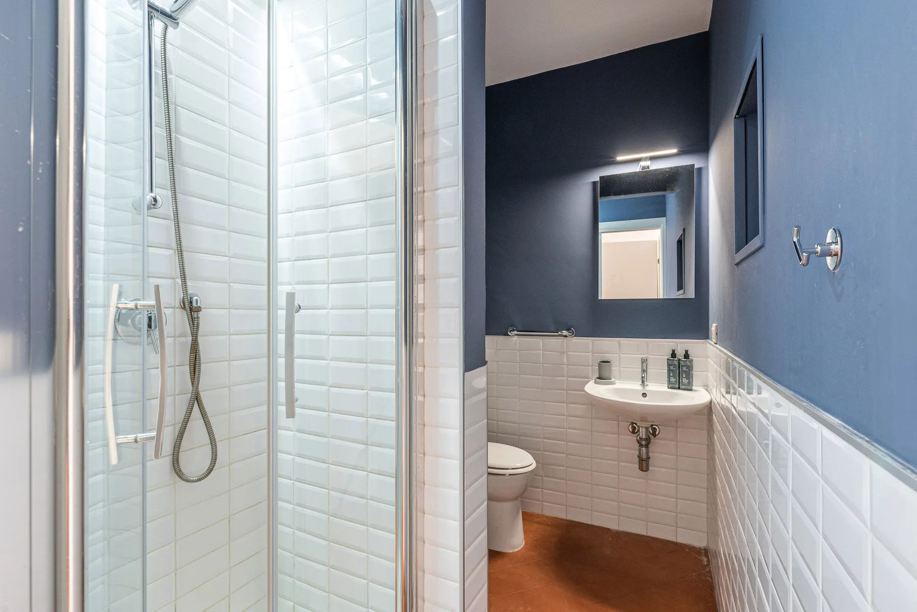 Un baño con ducha de vidrio, lavabo y espejo.