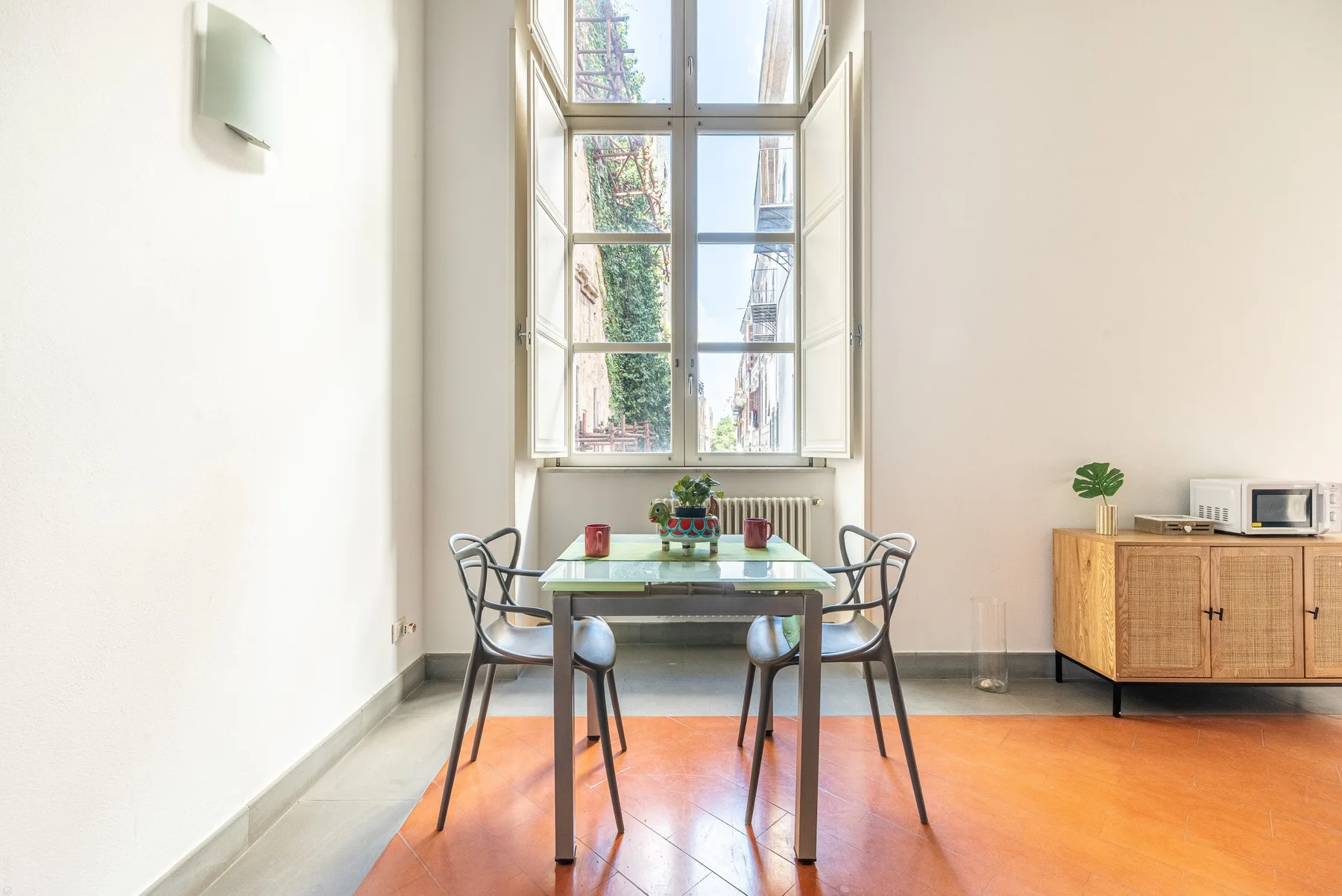 Un comedor luminoso con una mesa bajo una ventana alta.
