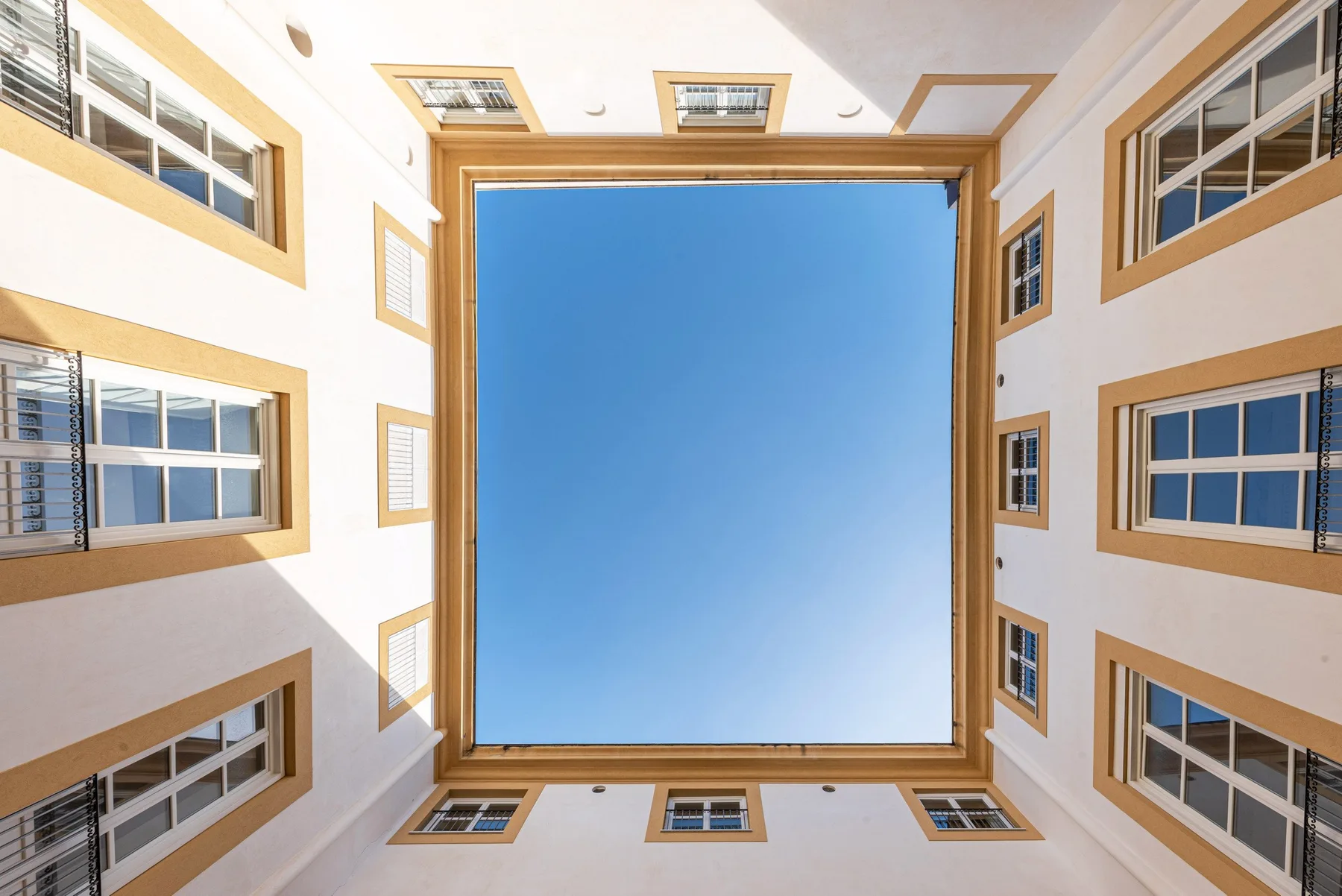Vista desde un patio hacia los edificios circundantes y un cielo azul despejado.