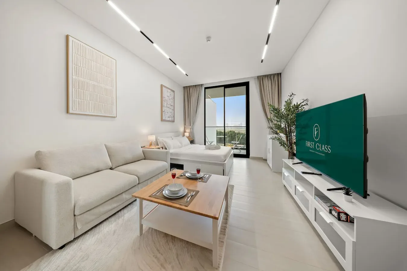 Una sala luminosa con sofá, mesa de centro y televisor.